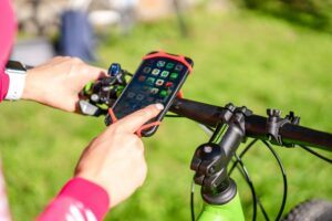 Cycliste amateur filmant un événement vélo avec un smartphone pour partager la sortie en ligne