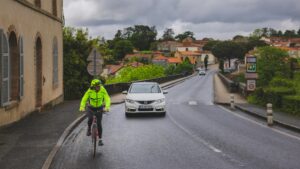 Ancienne course cycliste locale avec des coureurs traversant un village sous les encouragements des habitants
